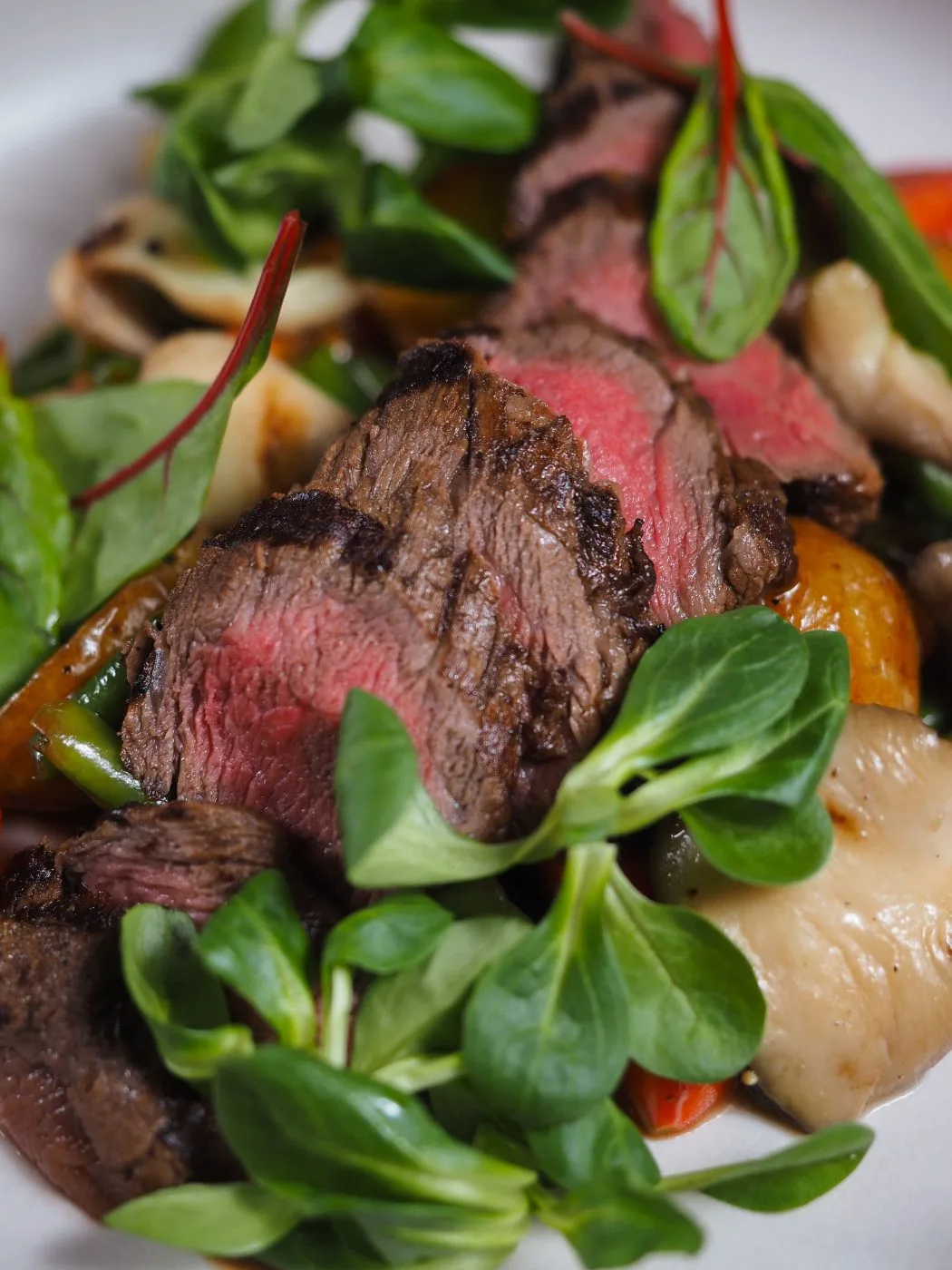 Tagliata di manzo al sangue con songino e verdure.