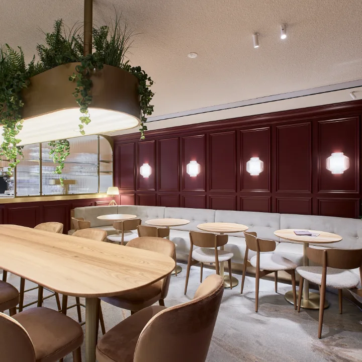 Bar con boiserie bordeaux, divanetto e tavoli in legno