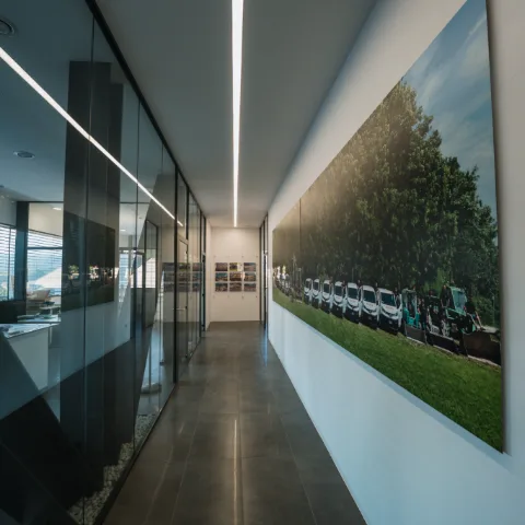 Corridoio di un ufficio con pareti vetrate e grande stampa fotografica