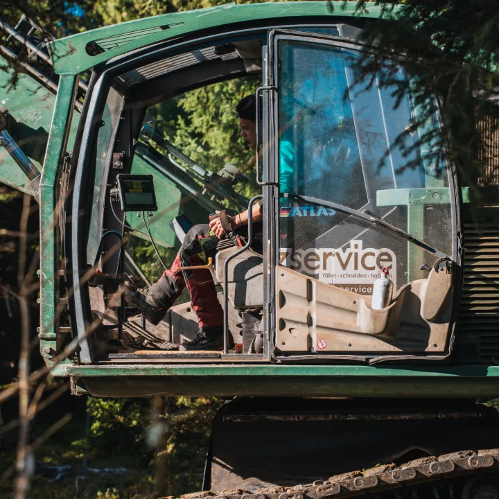 Operatore nella cabina di una macchina forestale cingolata