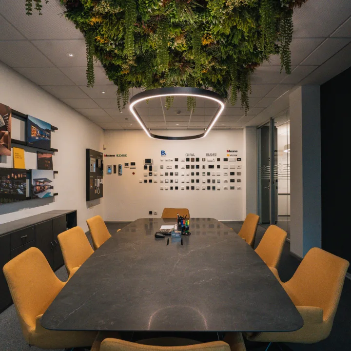 Sala riunioni con giardino verticale sul soffitto e sedie gialle